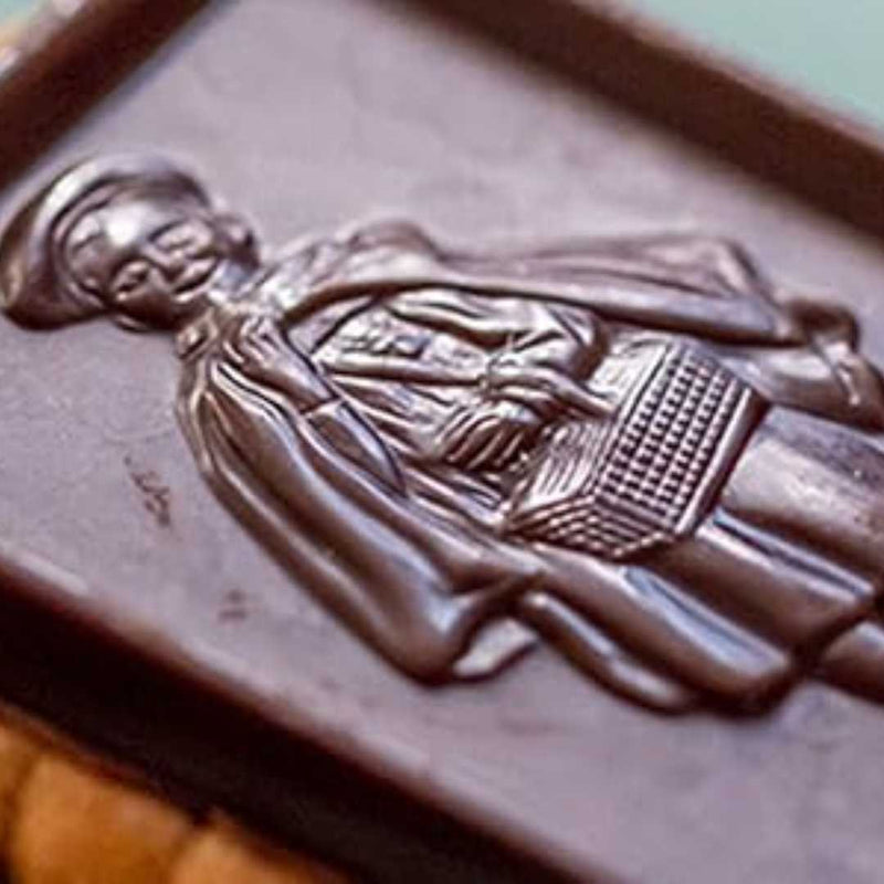 Chocolate bar with a silver embossed design of a person holding a book