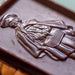 Chocolate bar with a silver embossed design of a person holding a book
