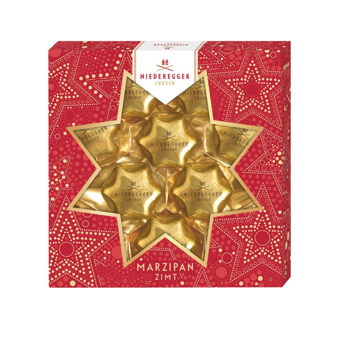 Gold star-shaped marzipan pieces in a red box with Niederegger branding.