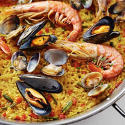 Seafood paella with shrimp, mussels, and clams on a yellow rice base.