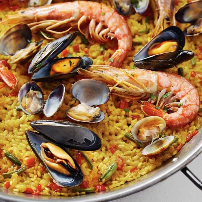 Seafood paella with shrimp, mussels, and clams on a yellow rice base.