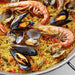 Seafood paella with shrimp, mussels, and clams on a yellow rice base.