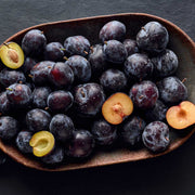 Plum fruits on a dark surface