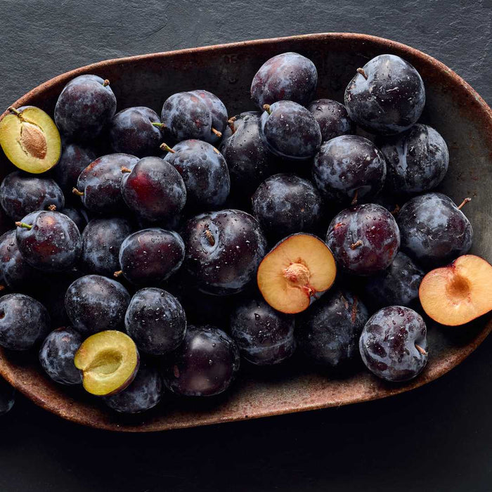 Plum fruits on a dark surface