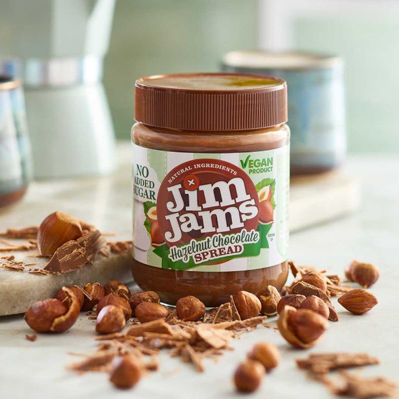 Jar of Jim Jamms Hazelnut Chocolate Spread with hazelnuts on a surface